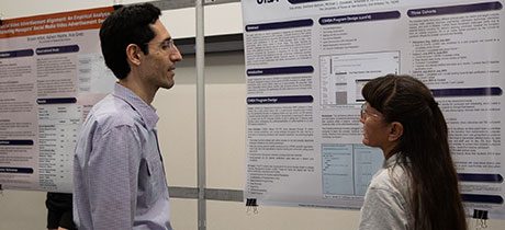 Two people talking at a poster presentation