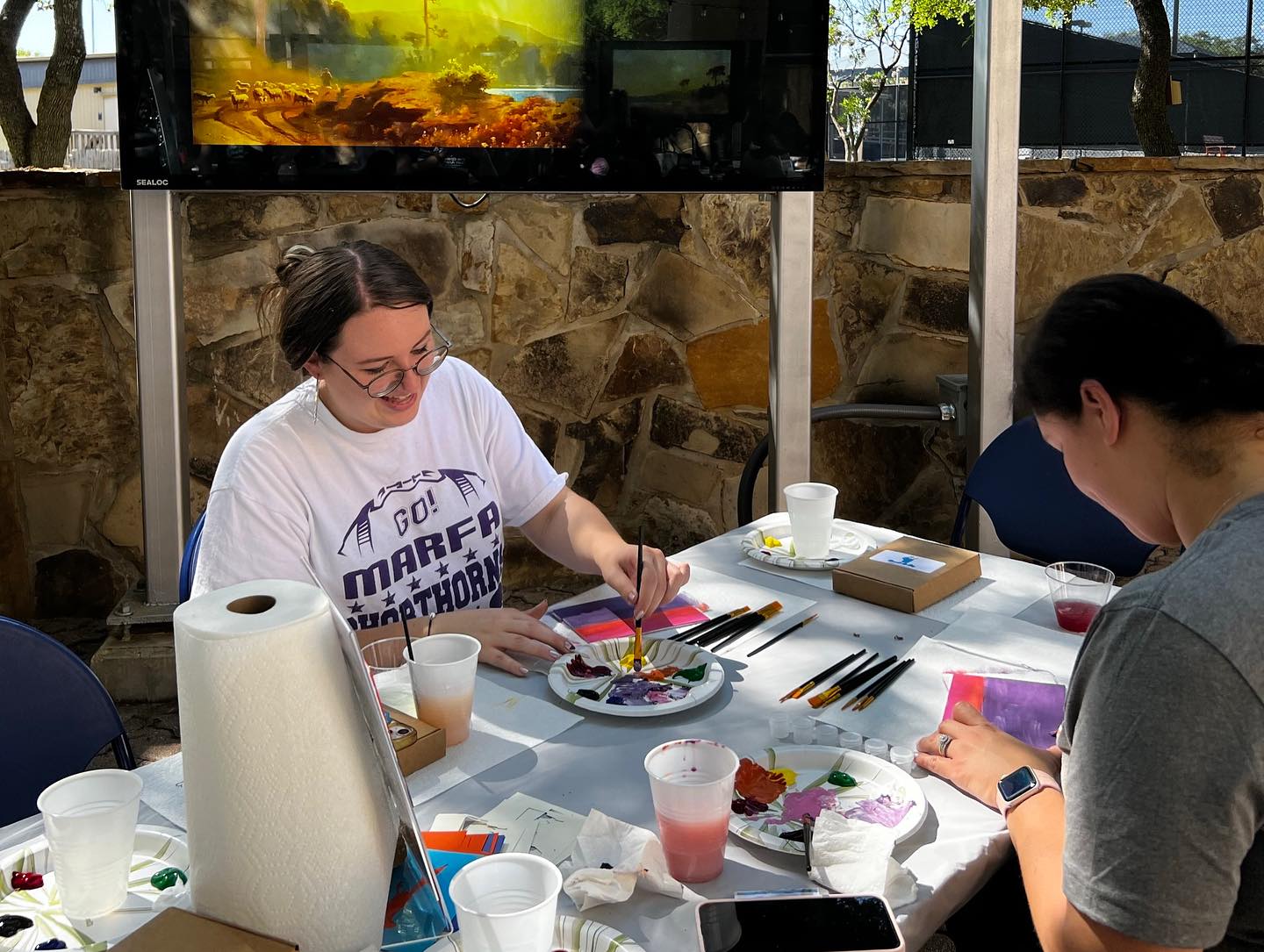 Two people at a table painting